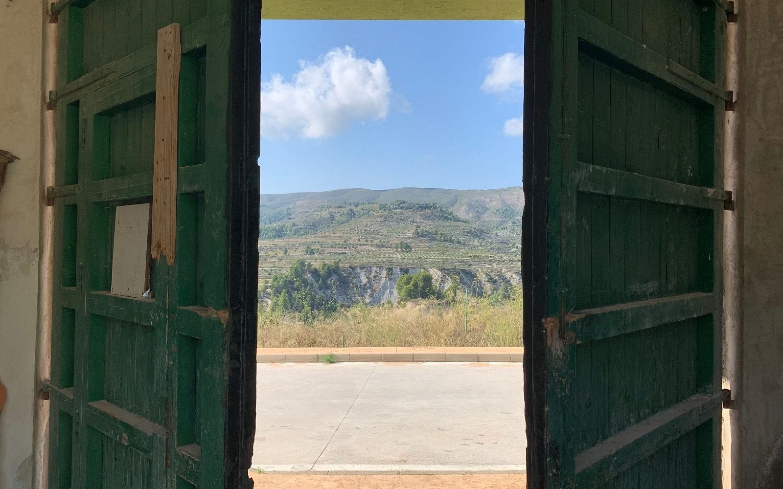 Groene deur met zicht op achterliggende berg aankoopbemiddelaar Spanje